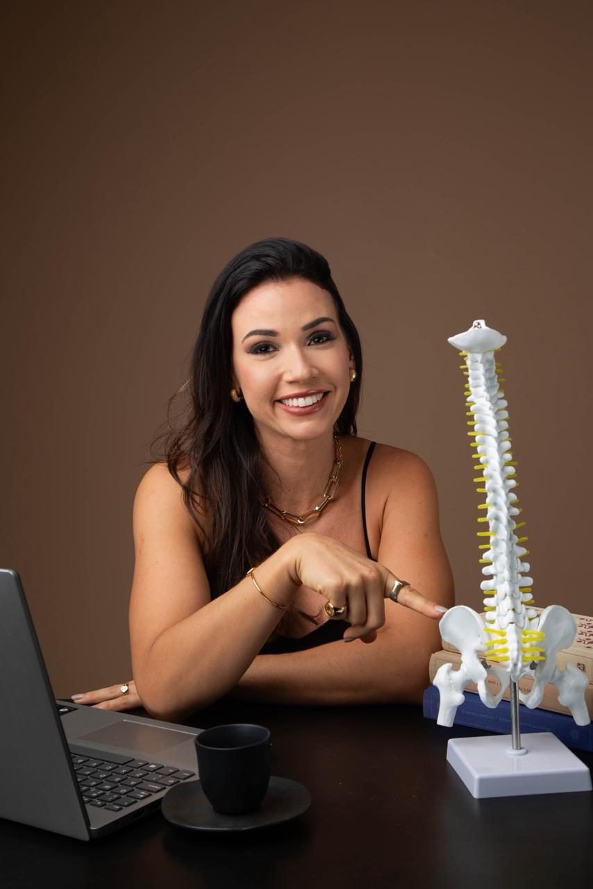Giselle Guimarães explicando um ajuste quiroprático em um modelo de coluna